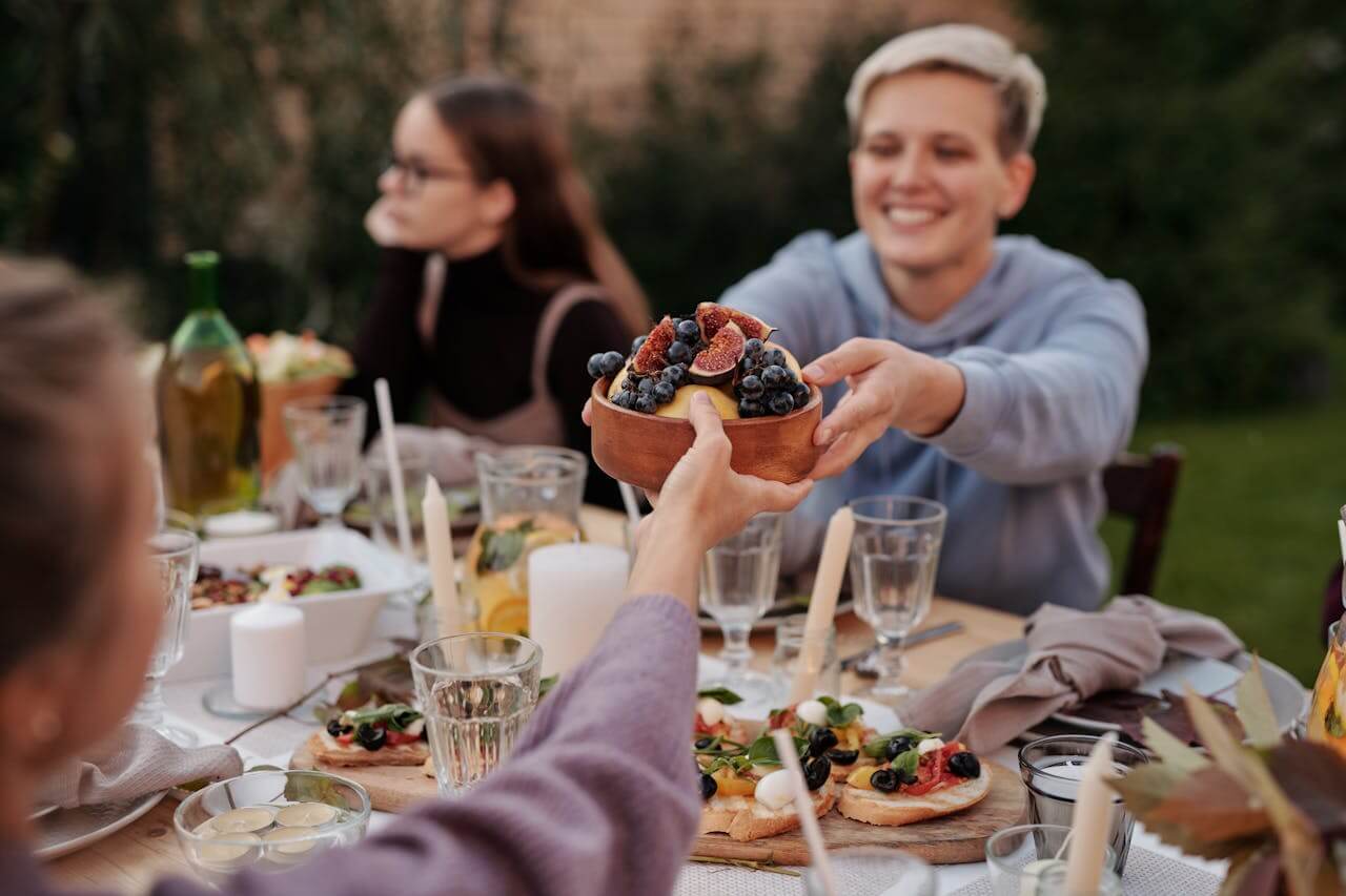 Person being handed bowl of fruit